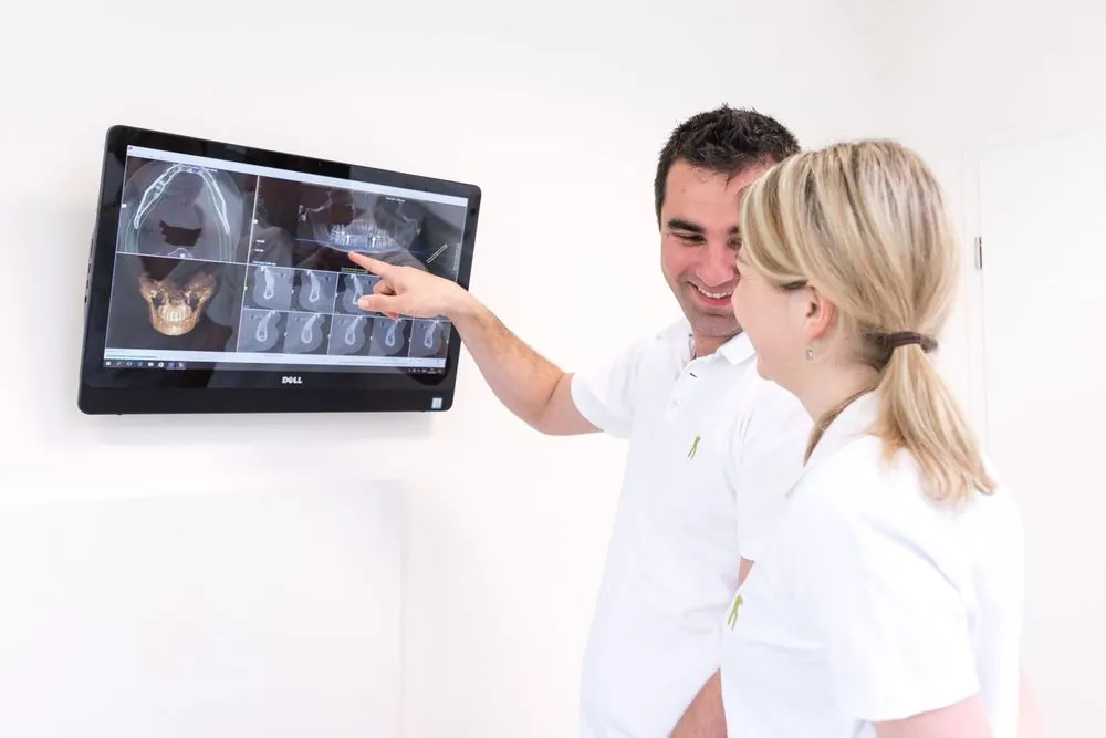 Lekár a sestra pri monitore s 3D CT snímkou čeľuste